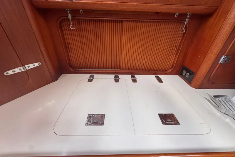 Slide: The Image of Interior of 1989 Little Harbor Sloop 58' with wooden cabinetry and storage compartments. - 58