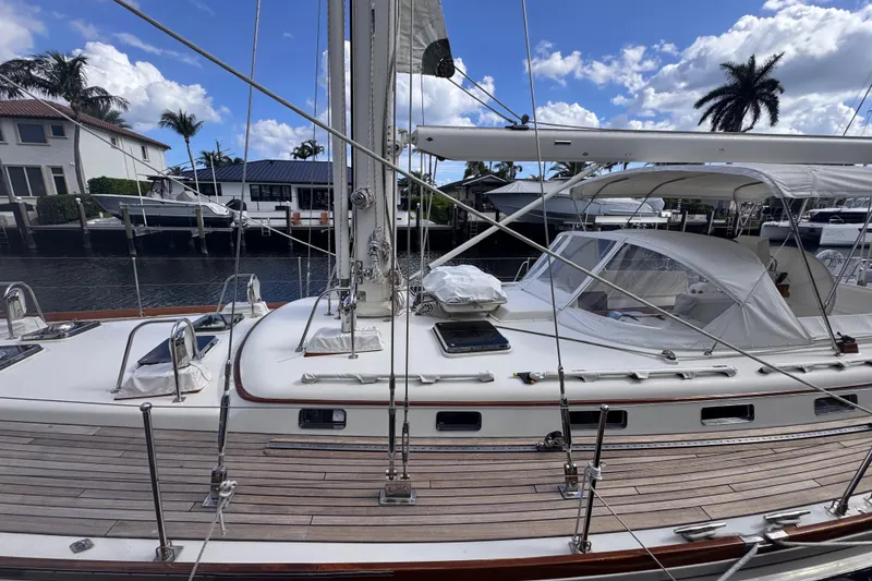 Slide: The Image of 1989 Little Harbor Sloop 58' docked, showcasing sleek design and spacious deck under blue skies. - 6