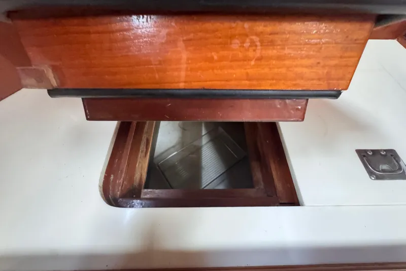 Slide: The Image of Interior view of 1989 Little Harbor Sloop 58', featuring wooden cabinetry and storage compartment. - 60