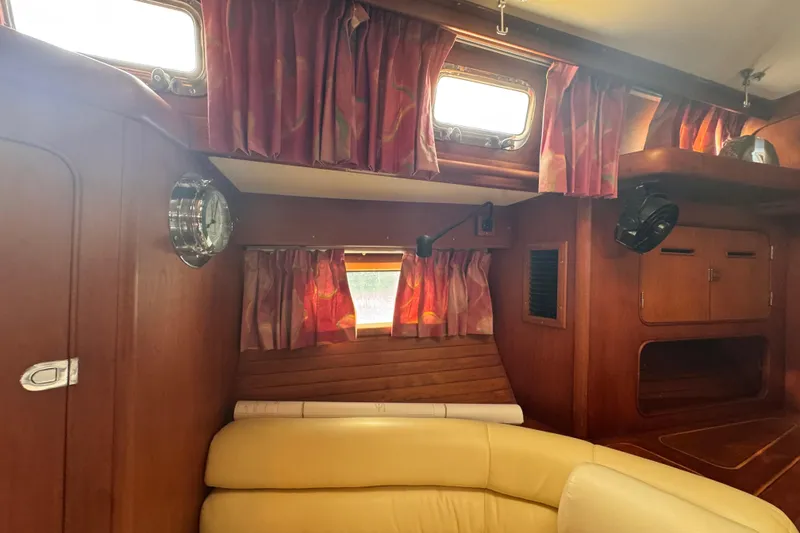 Slide: The Image of Interior of 1989 Little Harbor Sloop 58' with wood paneling and red curtains. - 88