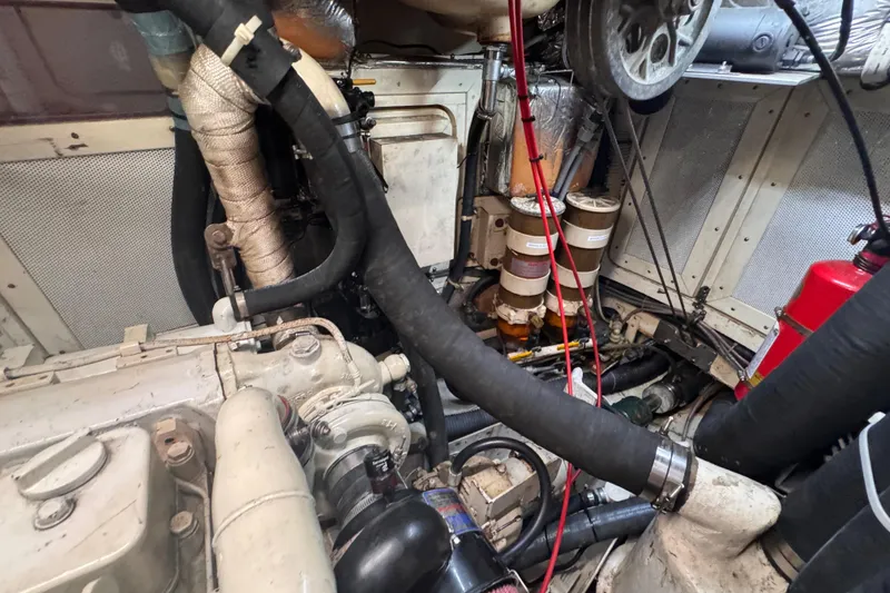 Slide: The Image of Engine room of a 1989 Little Harbor Sloop 58' with visible components and hoses. - 94