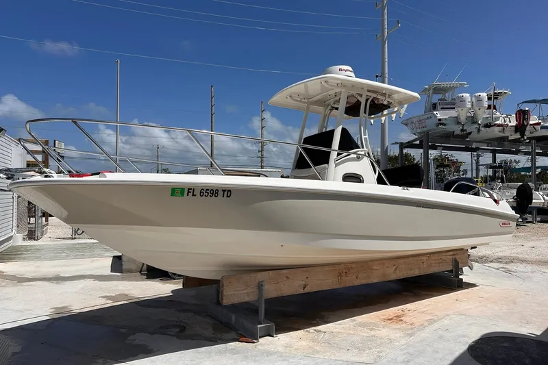 Slide: The Image of 2018 Boston Whaler Dauntless 240 boat on dry dock under clear blue sky. - 0