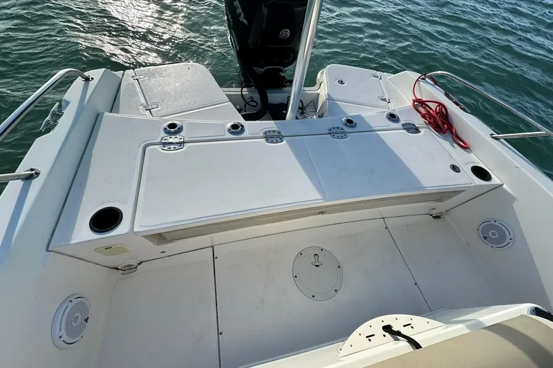 Slide: The Image of 2018 Boston Whaler Dauntless 240 boat deck with storage compartments and fishing rod holders. - 10