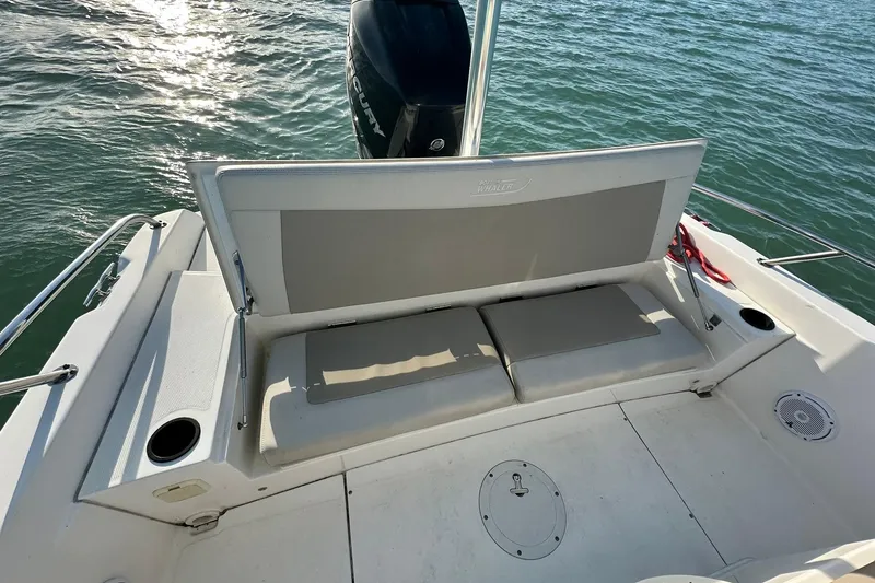 Slide: The Image of 2018 Boston Whaler Dauntless 240 boat interior with cushioned seating and Mercury engine. - 11