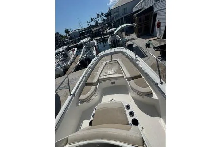 Slide: The Image of 2018 Boston Whaler Dauntless 240 boat docked at marina, showcasing spacious seating area. - 13