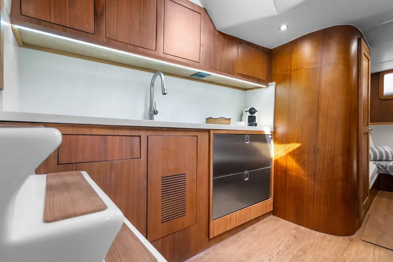 Slide: The Image of Luxurious 2025 Rybovich Custom Margaritavich yacht interior with modern wooden cabinetry and sleek design. - 24