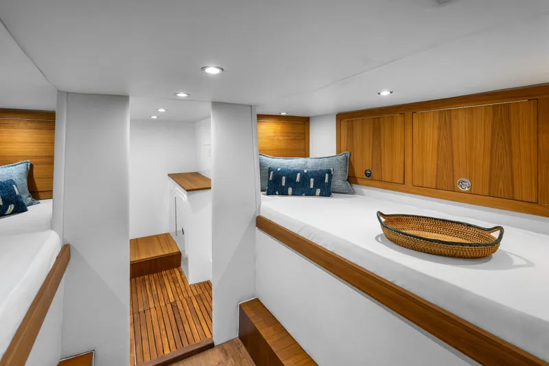 Slide: The Image of Luxurious 2025 Rybovich Custom Margaritavich yacht interior with wooden accents and cozy bedding. - 33