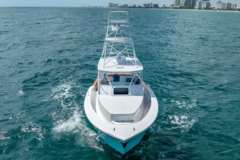 Slide: The Image of 2025 Rybovich Custom Margaritavich yacht cruising near a coastal city skyline. - 5