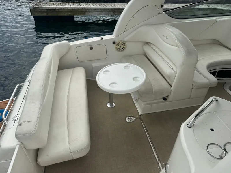 Slide: The Image of The image shows the cockpit of a 2005 Sea Ray Sundancer 280 with white seating and a round table. - 2