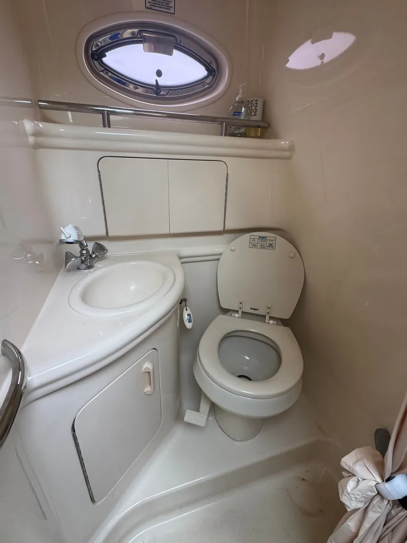 Slide: The Image of The image shows a compact boat bathroom with a sink, toilet, and porthole. - 10