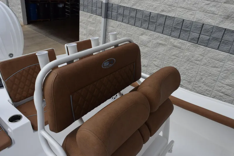 Slide: The Image of 2026 Sea Hunt BX 22 BR boat interior with brown cushioned seating and rod holders. - 10