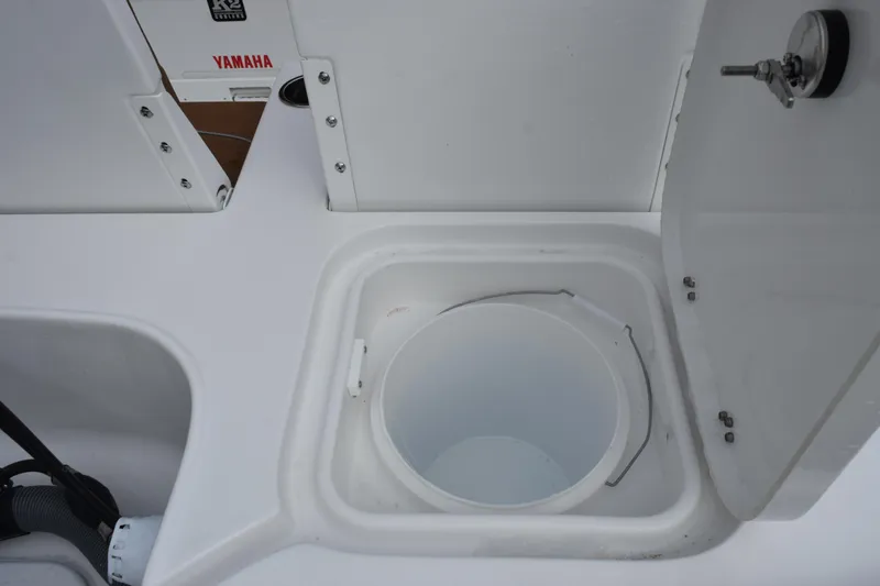 Slide: The Image of 2026 Sea Hunt BX 22 BR boat storage compartment with open lid and bucket. - 12