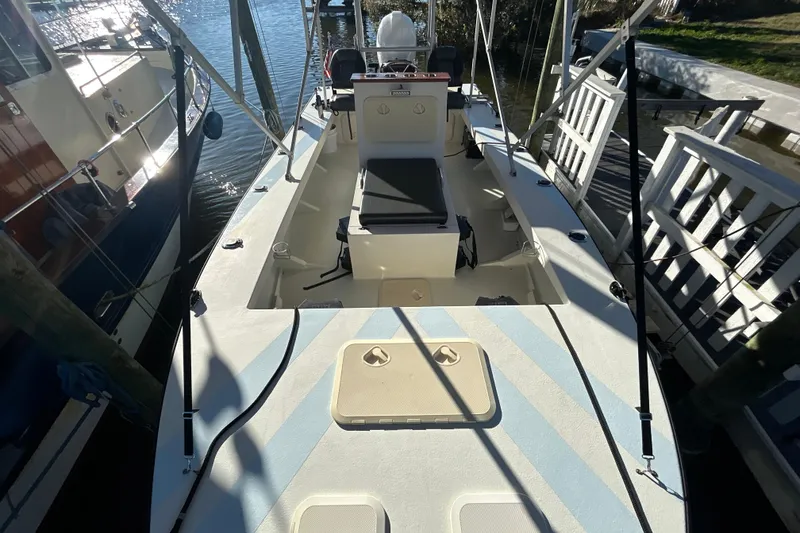 Slide: The Image of 2024 Custom Florida Flats CC boat docked, showcasing spacious deck and seating. - 13