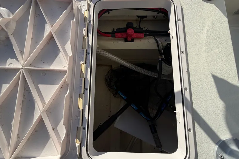 Slide: The Image of Open hatch of 2024 Custom Florida Flats CC boat showing internal wiring and components. - 18