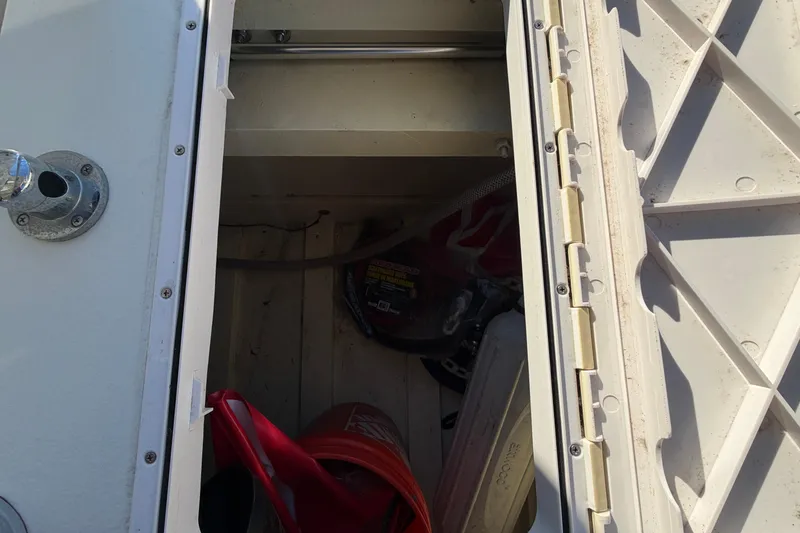 Slide: The Image of Open storage compartment on 2024 Custom Florida Flats CC boat, showing interior items. - 20
