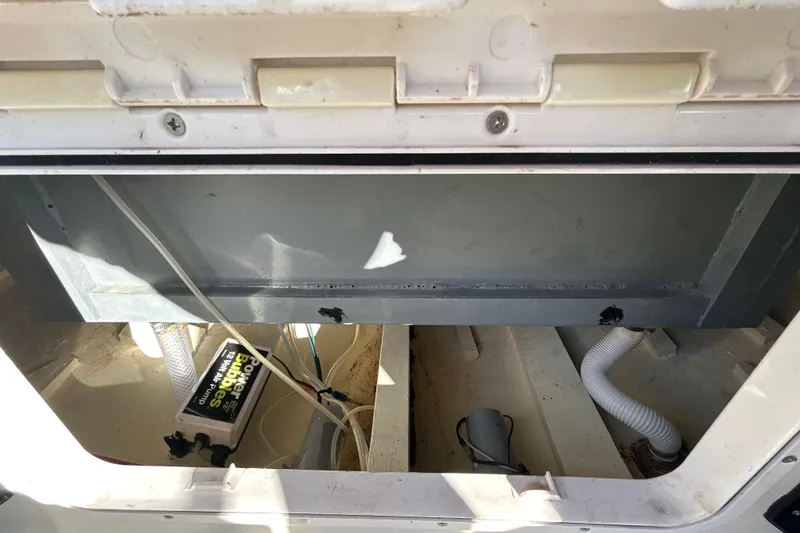 Slide: The Image of Open compartment of 2024 Custom Florida Flats CC boat showing battery and wiring. - 22