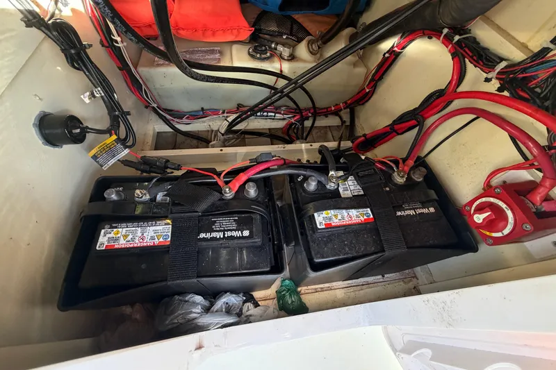 Slide: The Image of 2024 Custom Florida Flats CC boat battery compartment with dual West Marine batteries and wiring. - 24