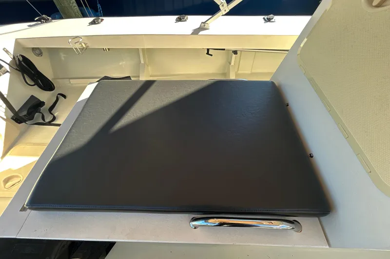 Slide: The Image of 2024 Custom Florida Flats CC boat interior with cushioned seating and storage area. - 28