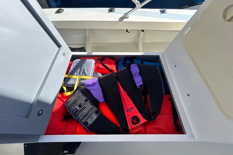 Slide: The Image of Storage compartment on 2024 Custom Florida Flats CC boat with life jackets and gear. - 29