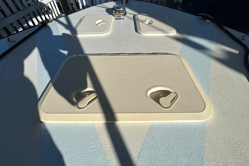 Slide: The Image of 2024 Custom Florida Flats CC boat deck with storage hatches and sunlight shadows. - 30