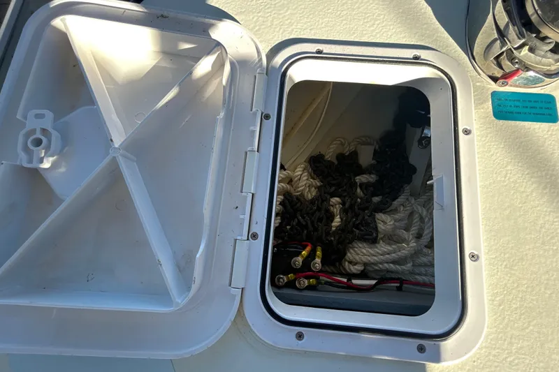 Slide: The Image of Open hatch on 2024 Custom Florida Flats CC boat showing ropes and wiring. - 33