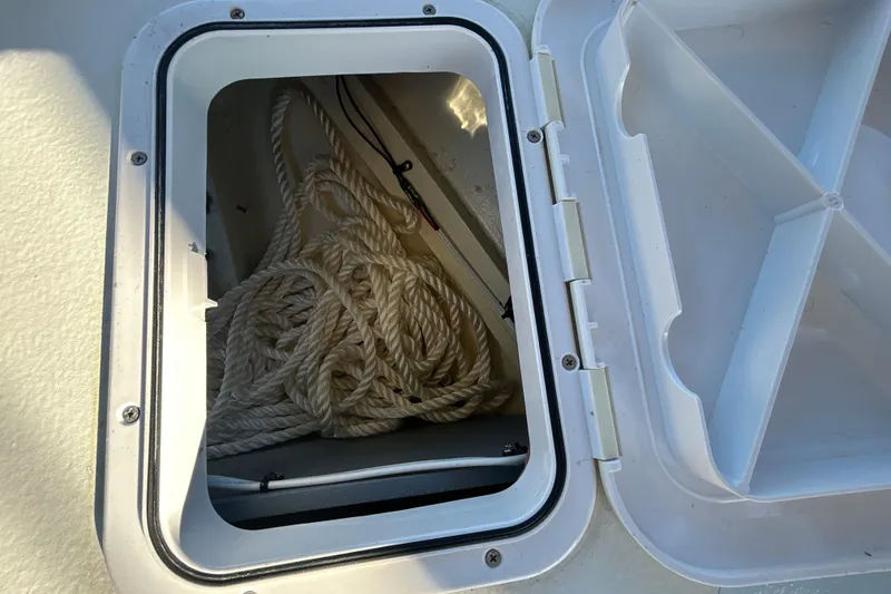 Slide: The Image of Open storage compartment on 2024 Custom Florida Flats CC boat with coiled rope inside. - 34