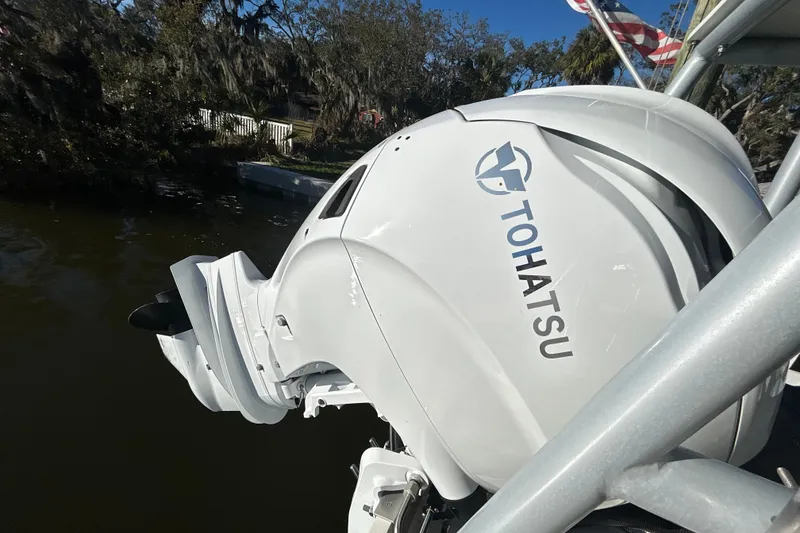 Slide: The Image of Tohatsu outboard motor on 2024 Custom Florida Flats CC boat, docked by water. - 4