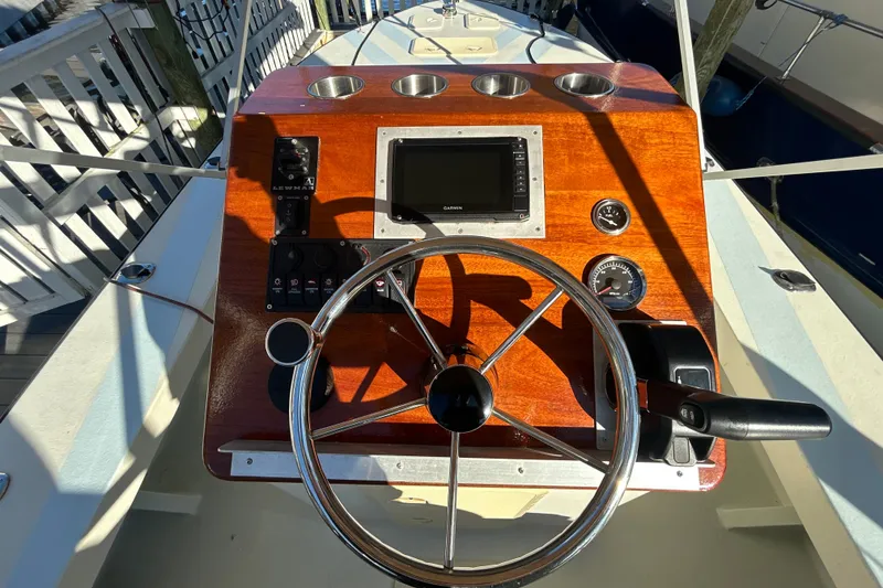 Slide: The Image of Steering console of 2024 Custom Florida Flats CC boat with wooden dashboard and modern controls. - 8