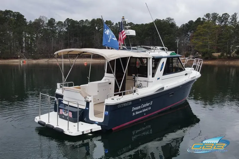 Slide: The Image of 2013 Cutwater C-28 boat on calm water, surrounded by trees. - 12