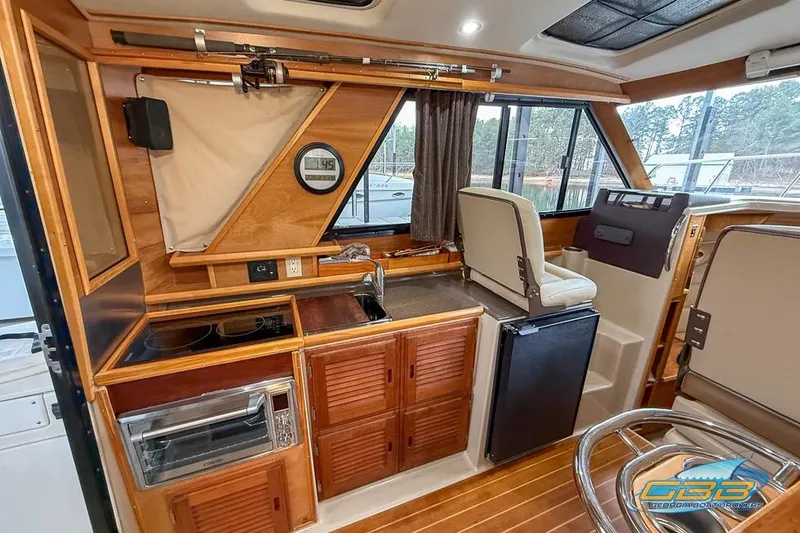 Slide: The Image of 2013 Cutwater C-28 boat kitchen with stove, oven, and wooden cabinetry. - 18