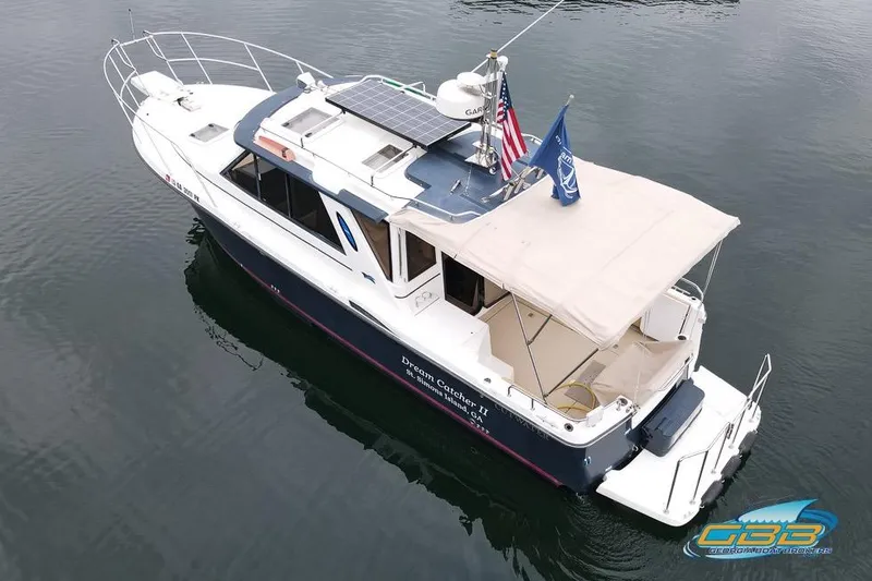 Slide: The Image of 2013 Cutwater C-28 boat, "Dream Catcher II," docked on calm water with flags. - 2