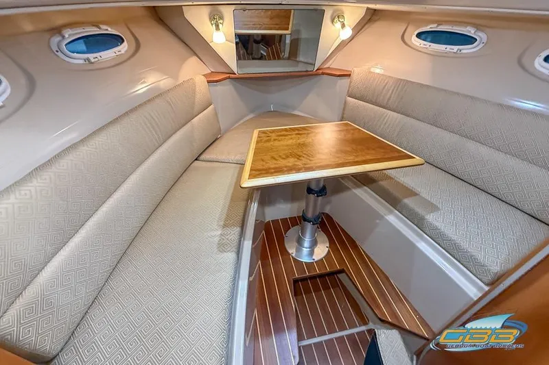 Slide: The Image of Interior of 2013 Cutwater C-28 boat with wooden table and beige seating. - 25