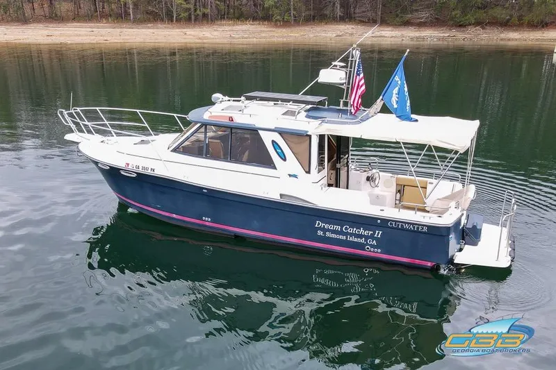 Slide: The Image of 2013 Cutwater C-28 boat with solar panels and flags, docked on calm water. - 3