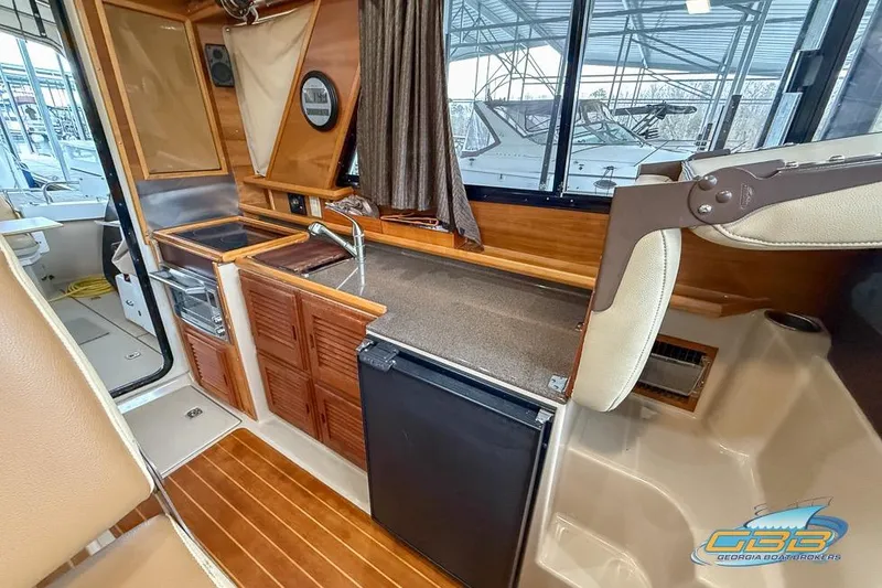 Slide: The Image of Interior of a 2013 Cutwater C-28 boat featuring a cushioned seat and wooden accents. - 41