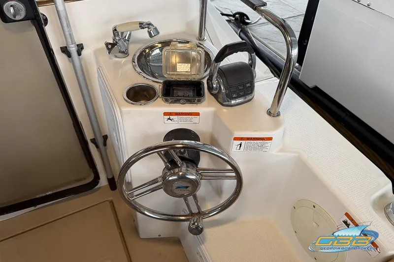 Slide: The Image of 2013 Cutwater C-28 boat interior with helm, seating, and wooden table. - 59