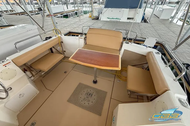 Slide: The Image of 2013 Cutwater C-28 boat docked, featuring a spacious deck and cabin windows. - 63