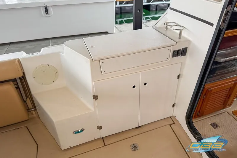 Slide: The Image of 2013 Cutwater C-28 boat deck with hatches and railing, docked by calm water. - 67