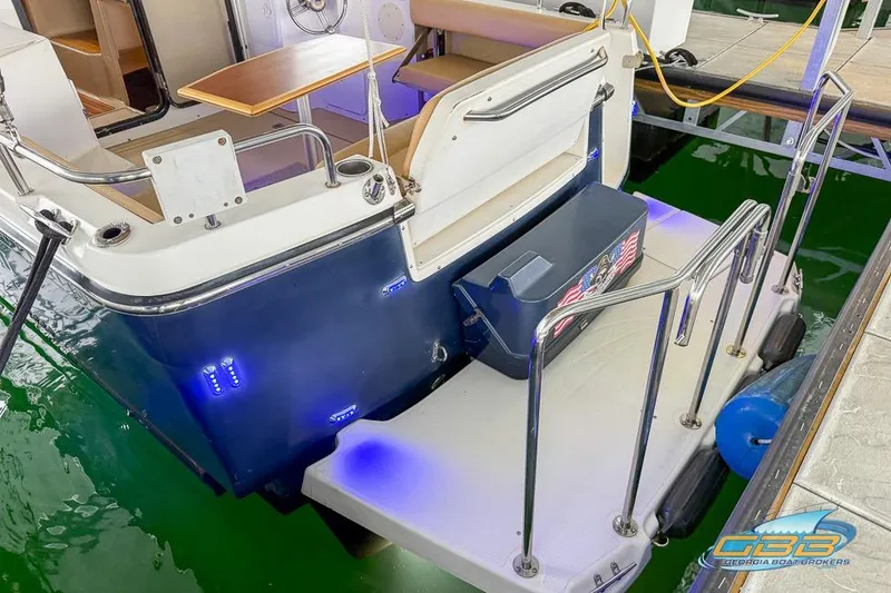 Slide: The Image of 2013 Cutwater C-28 boat docked, featuring swim platform and blue LED lights. - 79