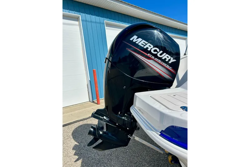 Slide: The Image of 2018 Starcraft 2000 OB Limited with Mercury FourStroke outboard motor, parked near blue building. - 10