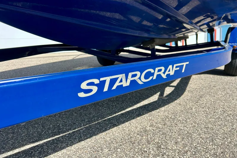 Slide: The Image of Blue Starcraft 2000 OB Limited boat trailer, 2018 model, on asphalt surface. - 41