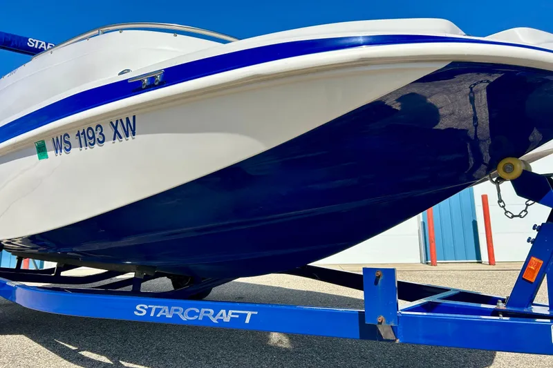 Slide: The Image of 2018 Starcraft 2000 OB Limited boat on trailer, blue and white design. - 7