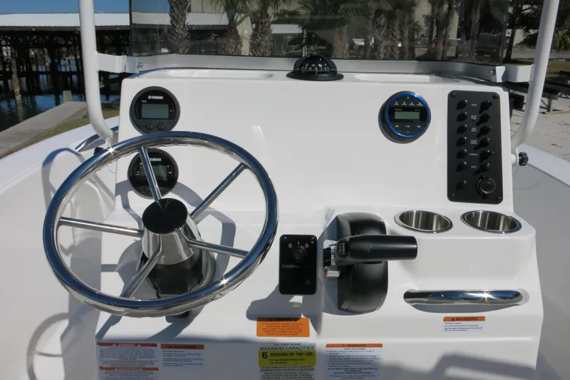Slide: The Image of 2026 Robalo R160 Center Console boat dashboard with steering wheel and controls. - 19