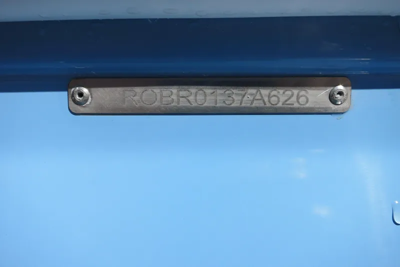 Slide: The Image of 2026 Robalo R160 Center Console boat identification plate on blue surface. - 23