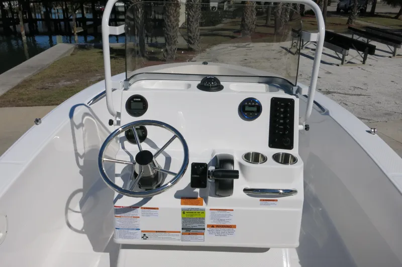 Slide: The Image of 2026 Robalo R160 Center Console boat dashboard with steering wheel and controls. - 8