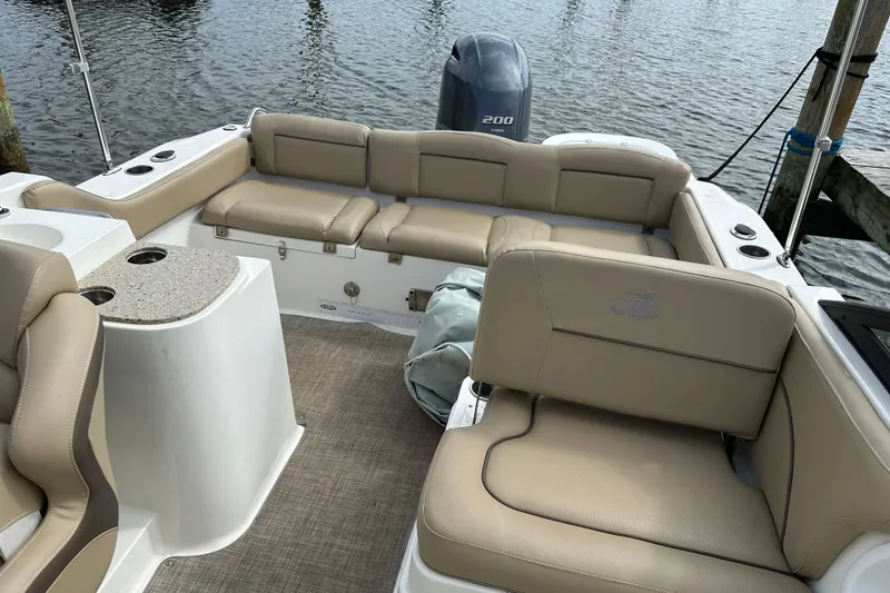 Slide: The Image of 2018 NauticStar 2302 Legacy Dual Console boat interior with beige seating and Yamaha outboard. - 18