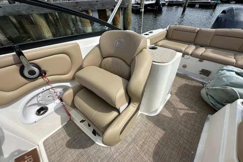 Slide: The Image of 2018 NauticStar 2302 Legacy Dual Console boat interior with beige seating and console. - 19