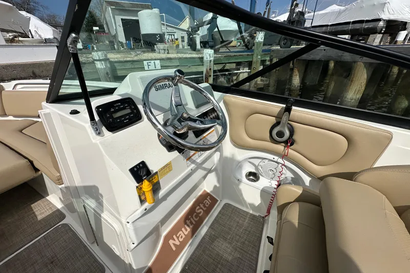 Slide: The Image of 2018 NauticStar 2302 Legacy Dual Console boat interior with steering wheel and controls. - 20
