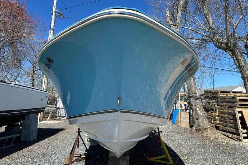 Slide: The Image of 2018 NauticStar 2302 Legacy Dual Console boat on dry dock, blue hull, outdoor setting. - 26