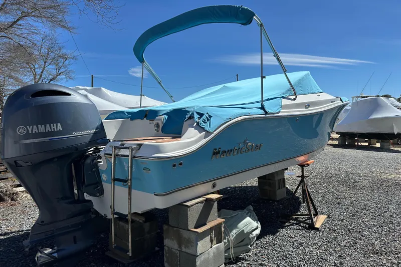 Slide: The Image of 2018 NauticStar 2302 Legacy Dual Console boat with Yamaha engine, covered and elevated. - 27