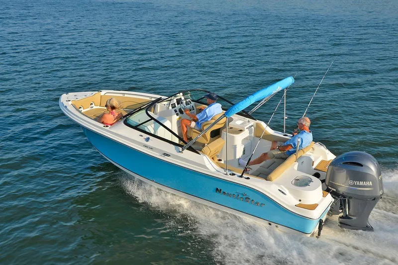 Slide: The Image of 2018 NauticStar 2302 Legacy Dual Console boat cruising on open water. - 3